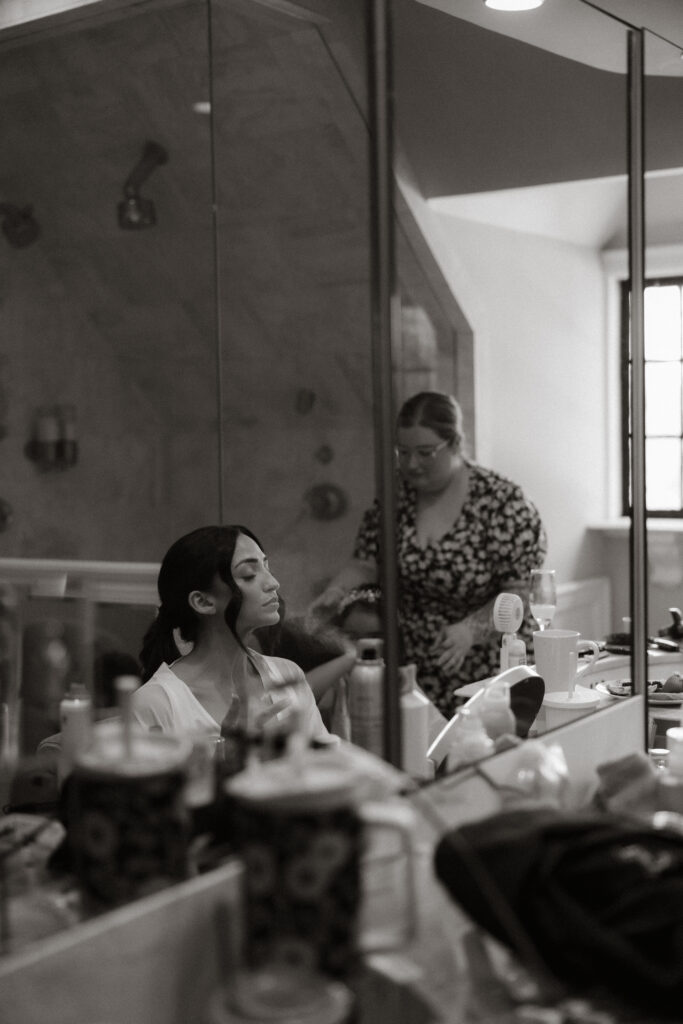 Bride getting ready in bathroom mirror reflection, Raleigh NC wedding photography