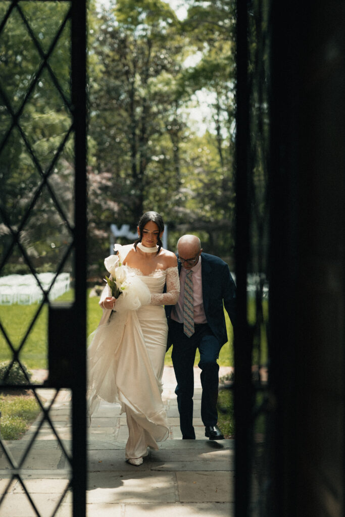 Father walking bride into ceremony, English Tudor style wedding venue