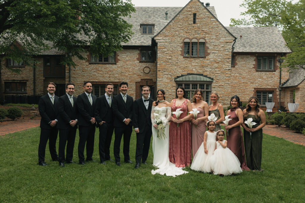 Full wedding party portrait in front of stone manor house, Raleigh NC wedding
