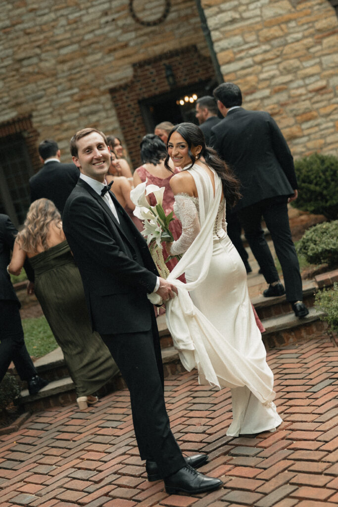 Bride and groom laughing on brick steps, calla lily bouquet, NC estate wedding