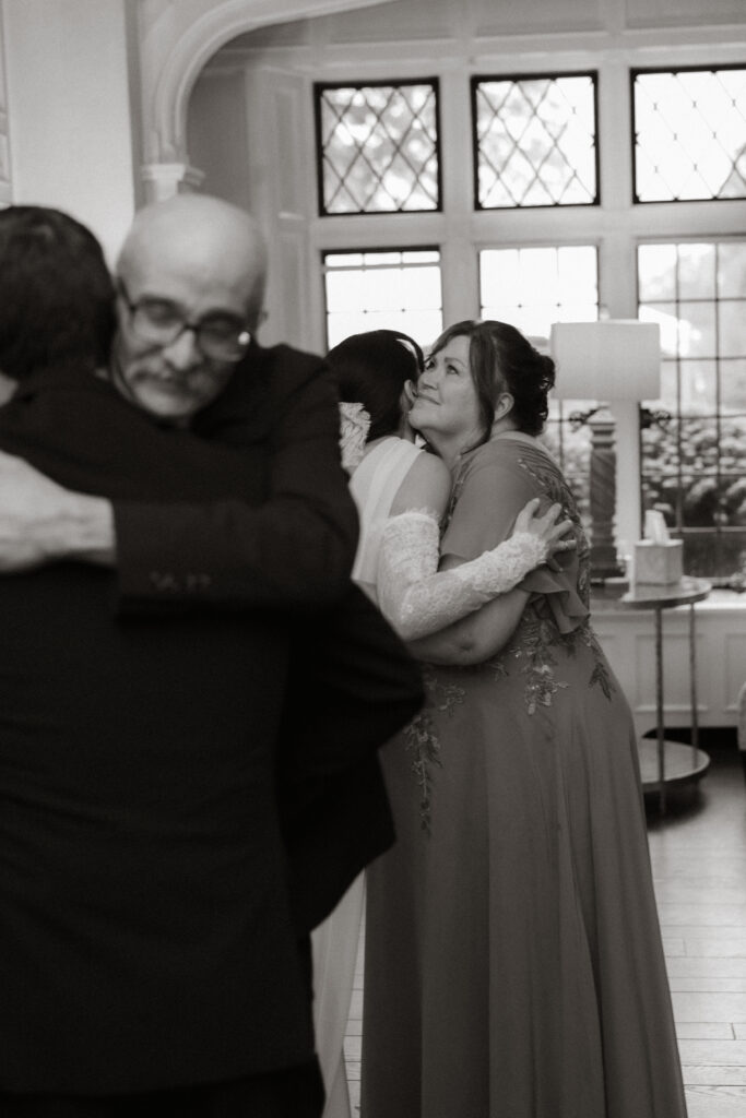 Father embracing mother of the bride, emotional wedding moment, black and white