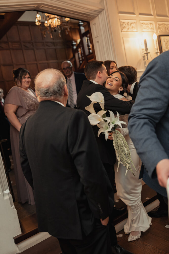 Bride hugging guests during wedding reception, candid moment