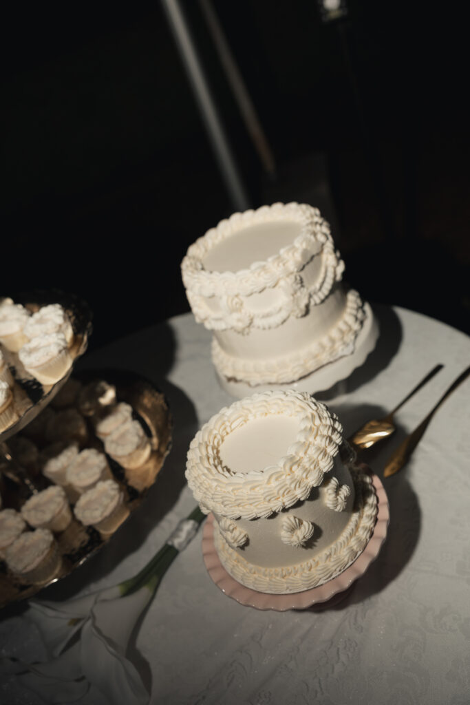 Tiered wedding cakes with piped buttercream detail on dessert table