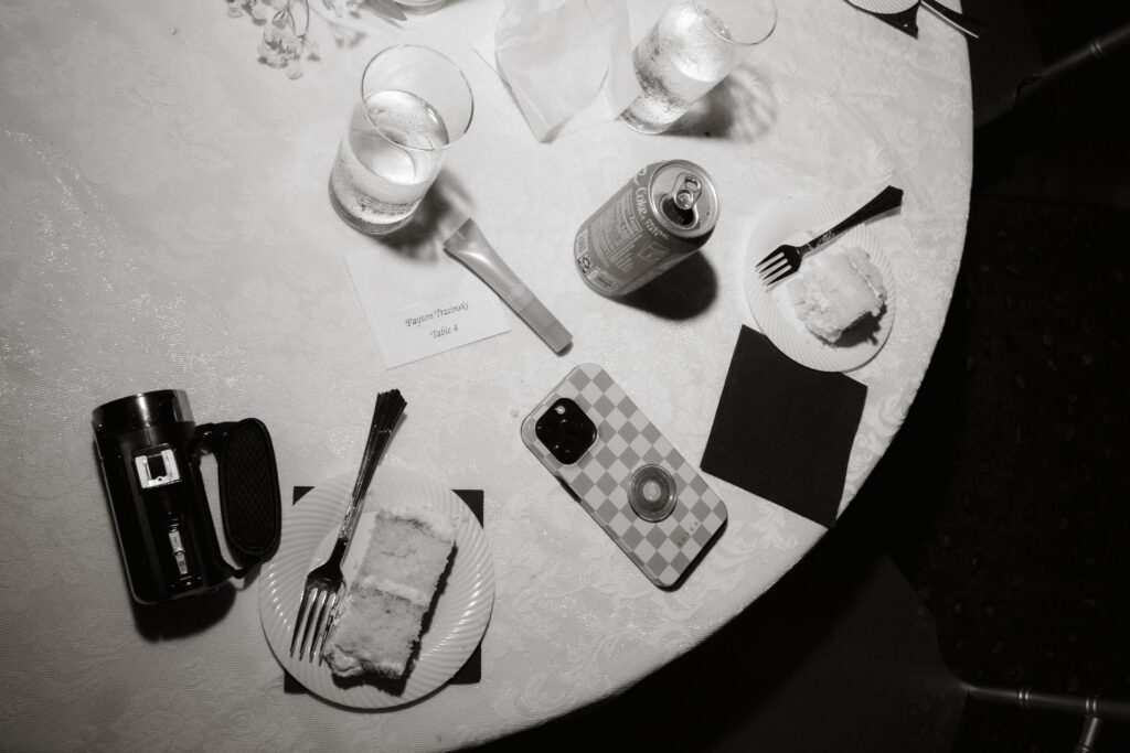 Wedding reception tablescape with cake slice and drinks, flat lay