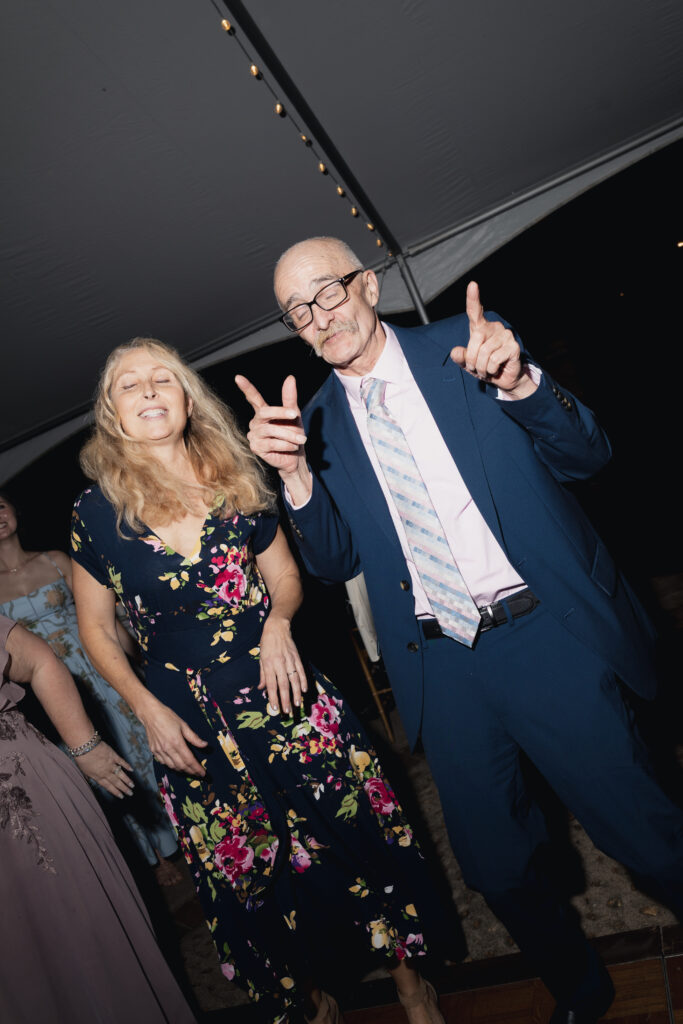 Wedding guests dancing and celebrating under string lights at night