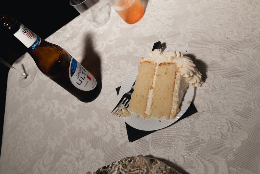 Cake slice and beer bottle on table at wedding reception